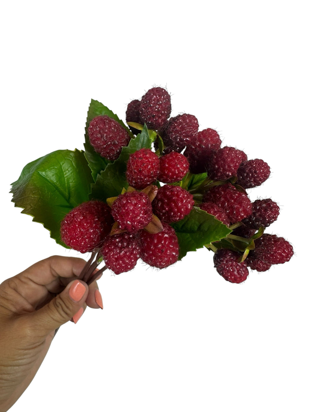 Artificial Bloom artificial raspberry fruit stem with realistic red berries and green leaves held in a hand