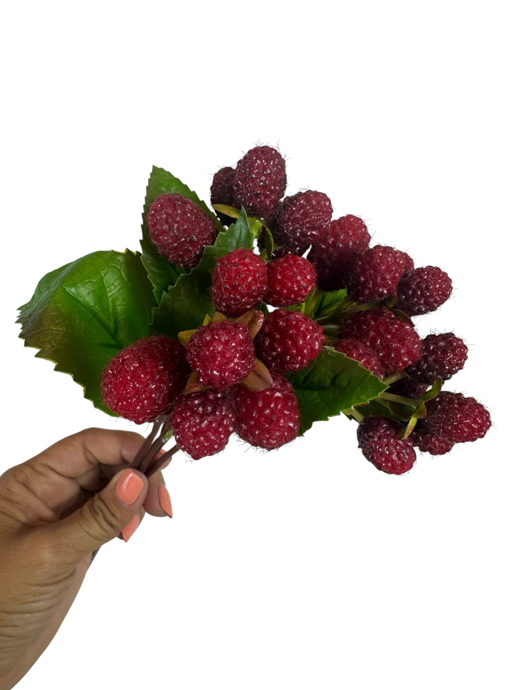Artificial Bloom artificial raspberry fruit stem with realistic red berries and green leaves held in a hand