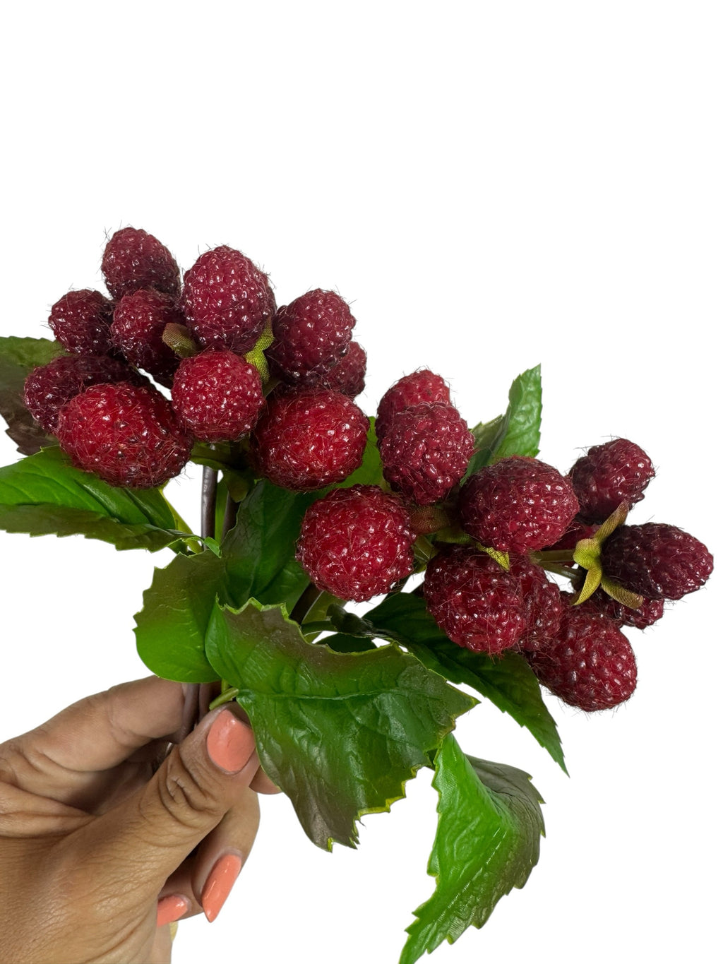 Artificial Bloom artificial raspberry fruit stem with realistic red berries and green leaves held in a hand