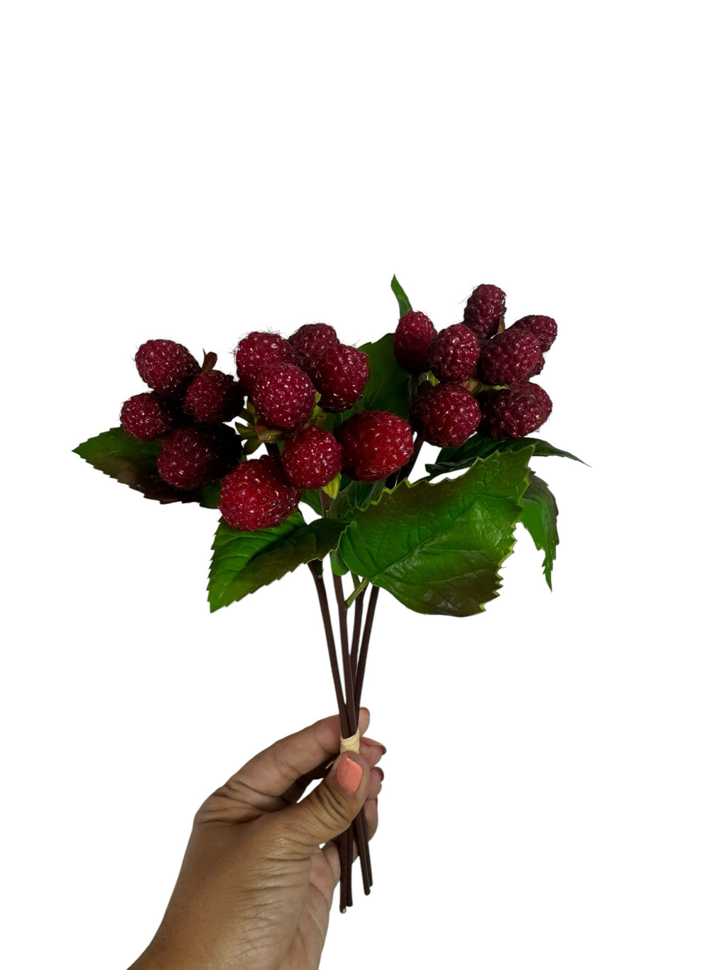 Artificial Bloom artificial raspberry stem with textured red berries and green leaves held in a hand