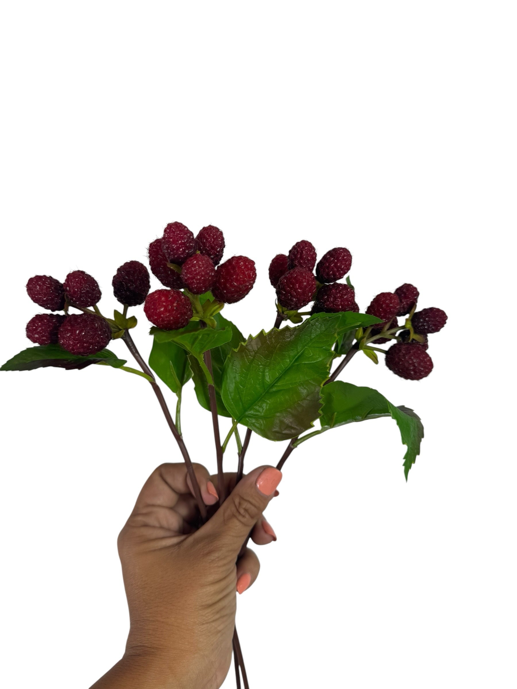 Artificial Bloom artificial raspberry fruit stem with realistic deep red berries and green leaves held in a hand