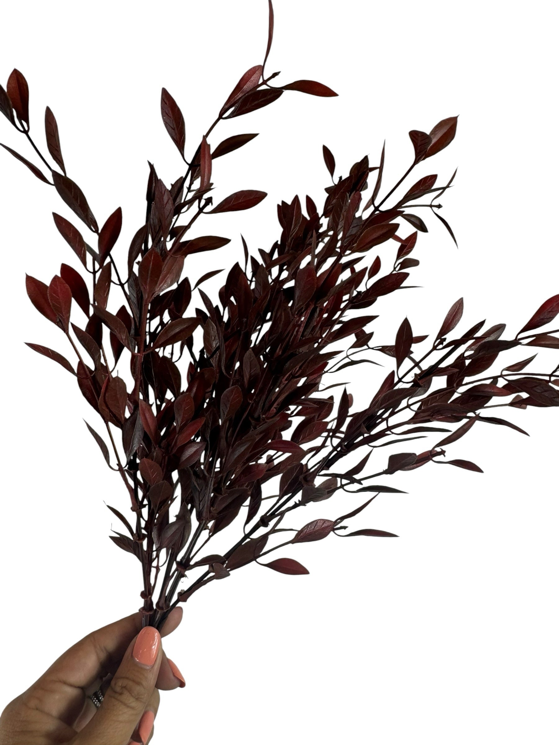 Artificial Bloom deep burgundy faux leafy branch stem held in hand, featuring realistic dark red foliage for home decor.