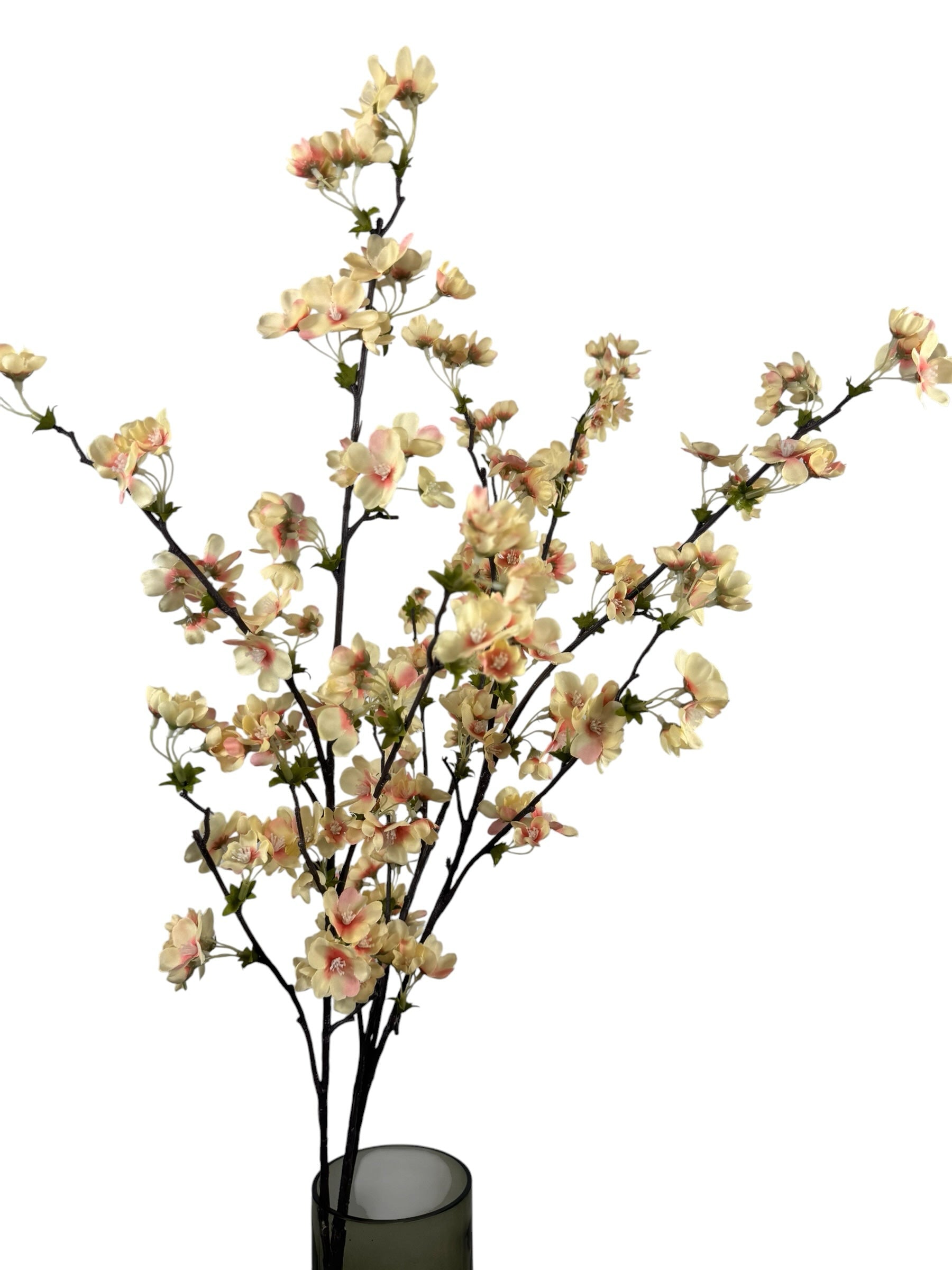 Artificial Bloom decorative cherry blossom branch with cream and blush-pink petals on dark textured stems in a vase.