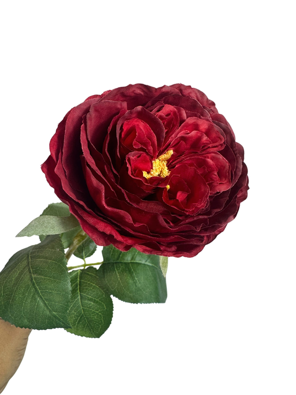 Artificial Bloom deep red faux rose stem with velvety petals and realistic green foliage against a white background