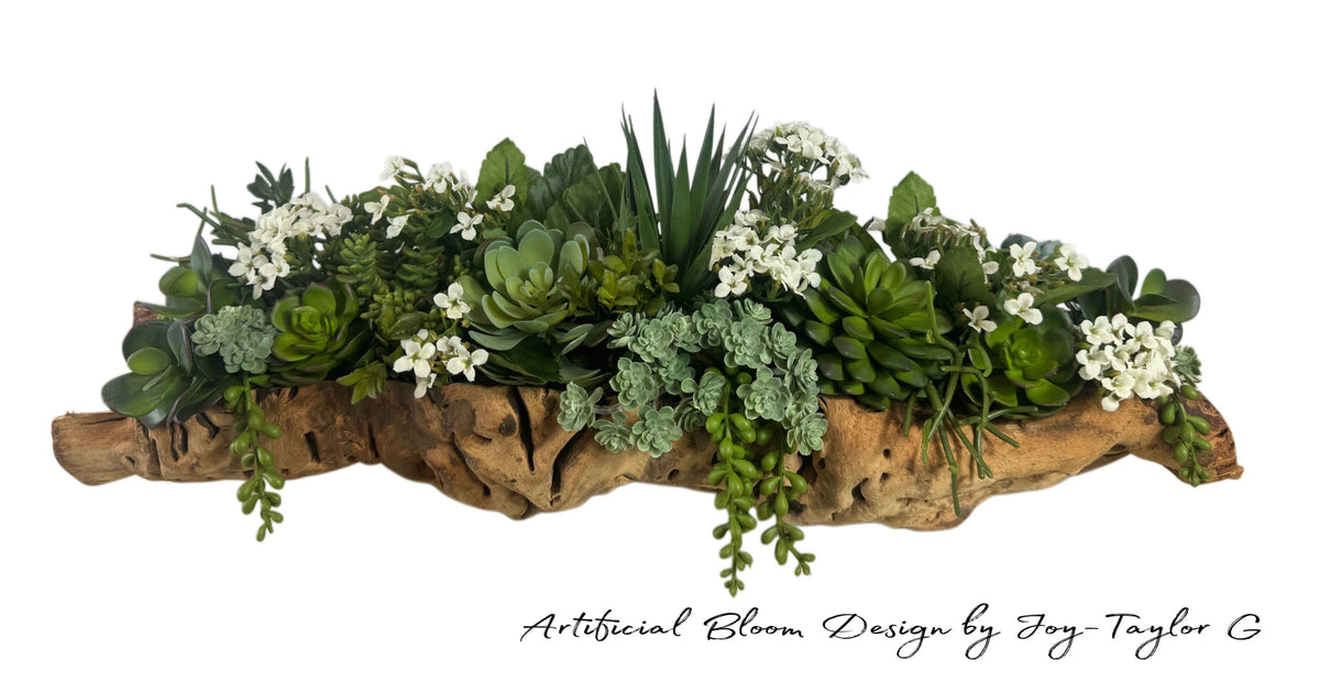 Artificial Bloom succulent arrangement featuring lifelike green plants and white flowers in a rustic driftwood base.