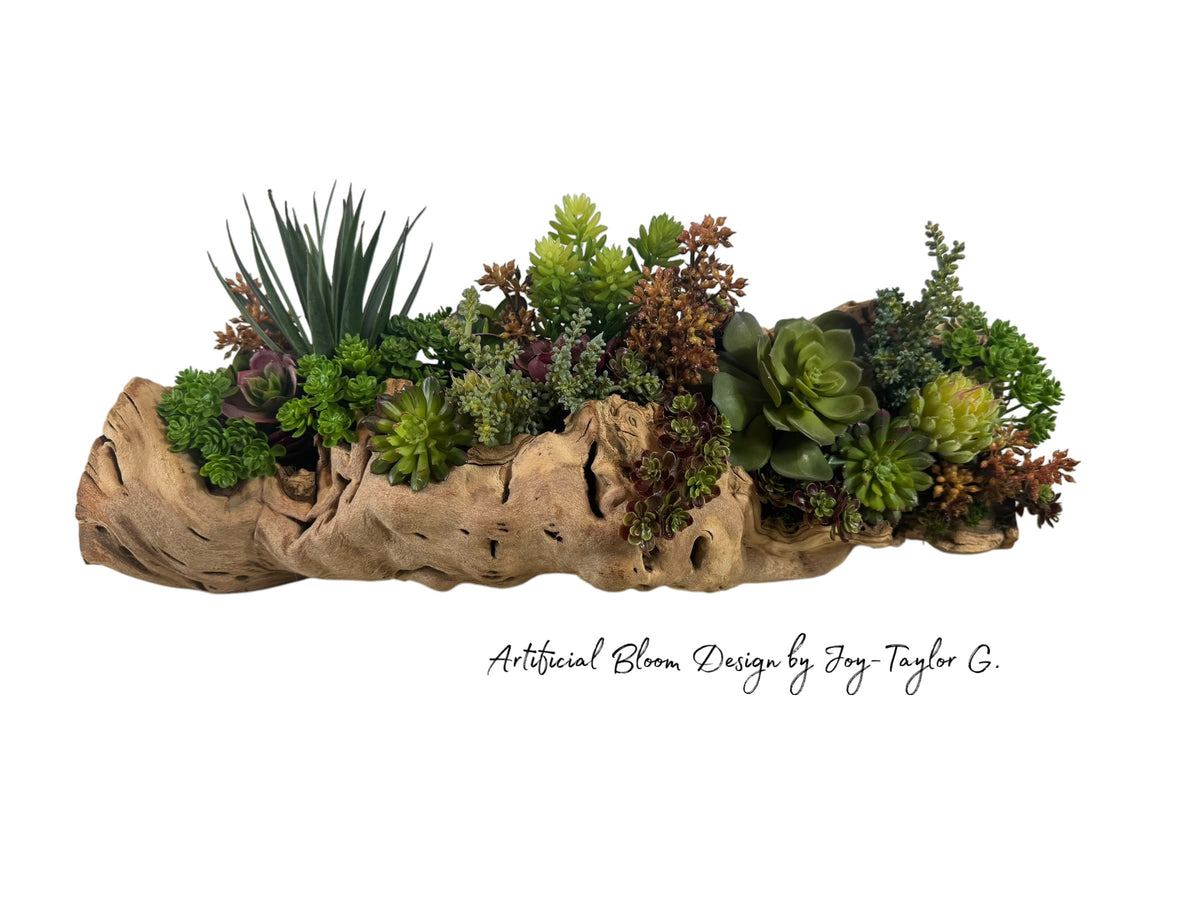 Artificial Bloom succulent arrangement featuring diverse green and purple plants in a rustic natural driftwood base.