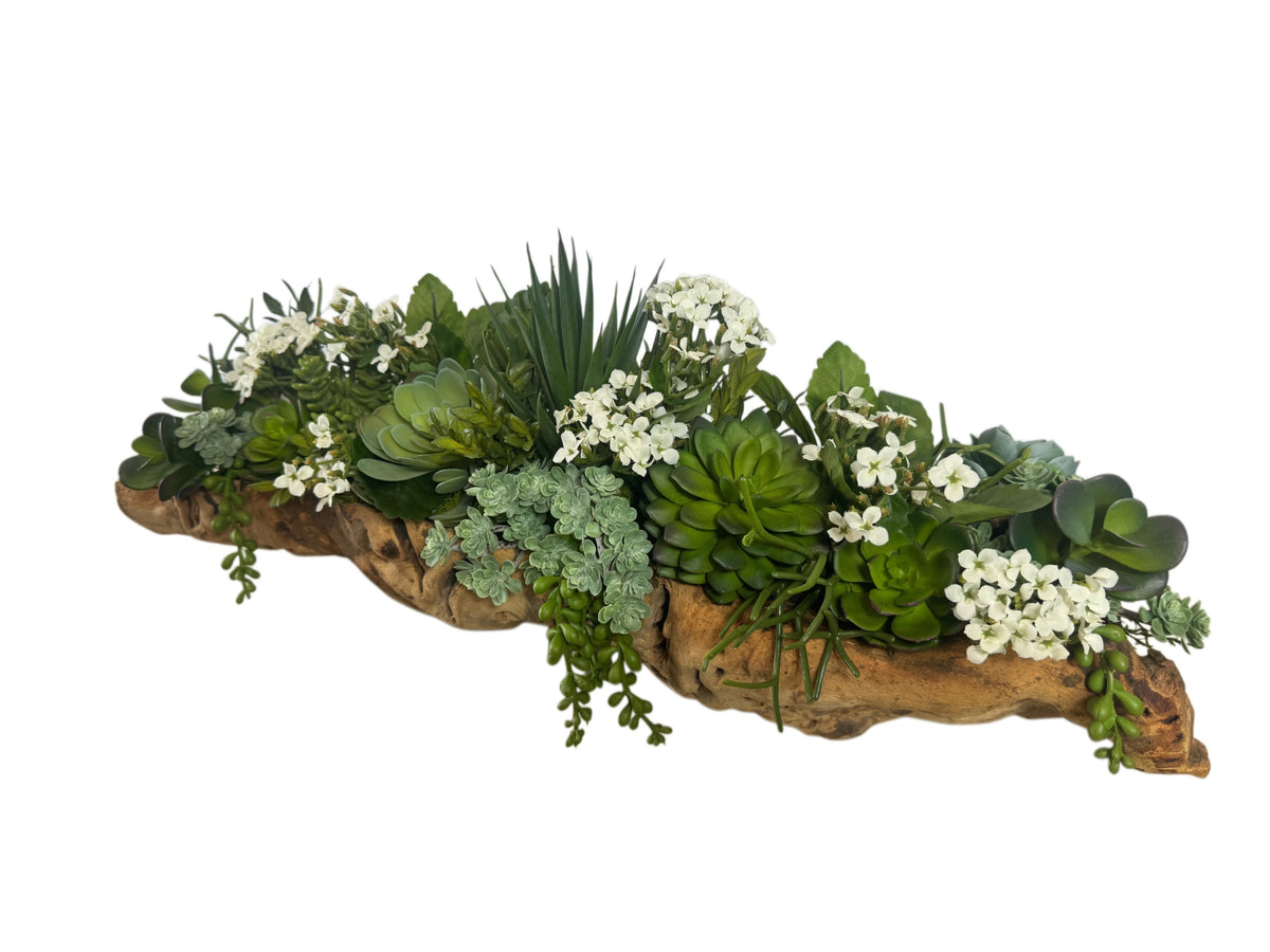 Artificial Bloom succulent arrangement featuring lifelike green plants and white flowers in a rustic driftwood base.