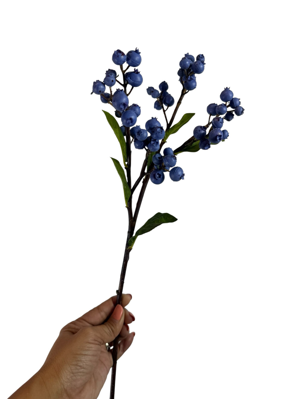 Artificial Bloom decorative faux blueberry stem with realistic deep blue berries and green leaves held in a hand