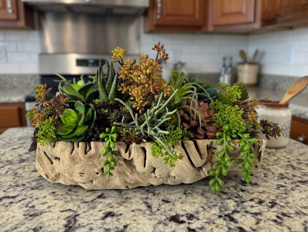 Artificial Bloom artificial succulent arrangement in a textured driftwood-style bowl with green and rust-toned plants.