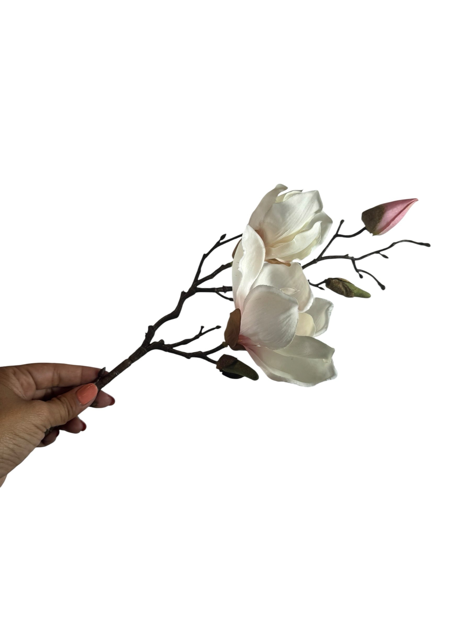 Artificial Bloom magnolia flower stem with creamy white petals, pink buds, and a dark rustic branch held by a hand.