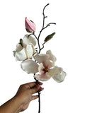 Artificial Bloom magnolia stem with creamy white petals, pink undertones, and realistic buds held against white