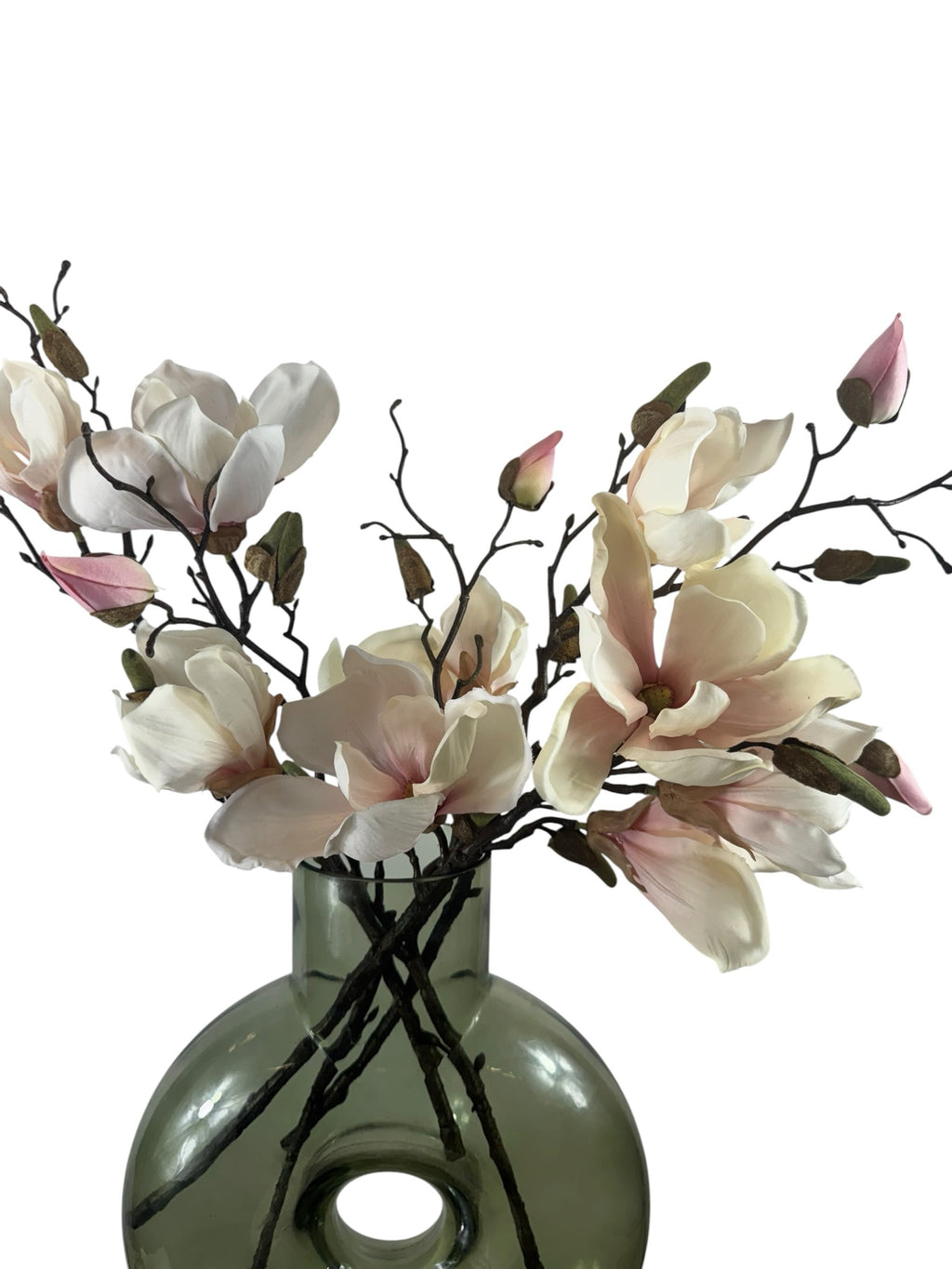 Artificial Bloom magnolia flower stem with white and pink petals in a green glass vase against a white background