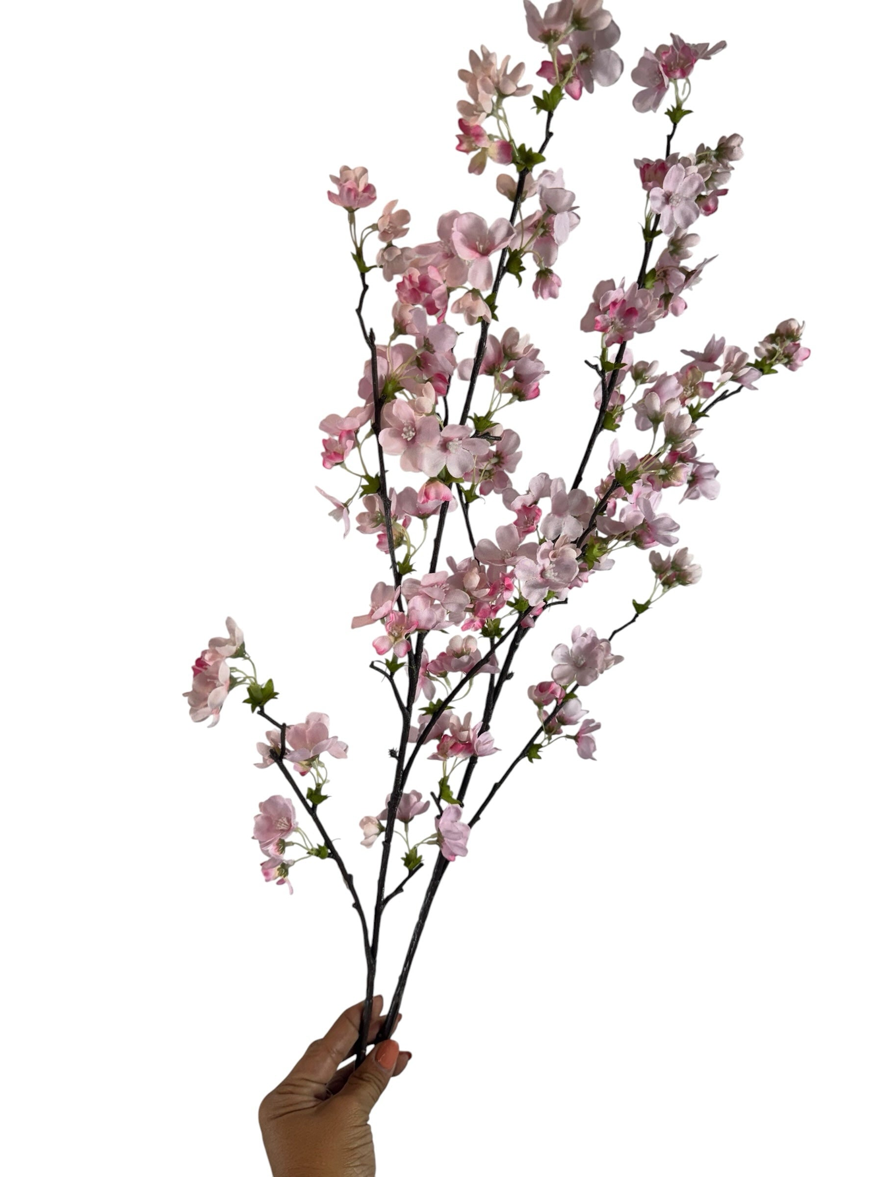 Artificial Bloom artificial cherry blossom stem with soft pink petals and dark textured branches held by a hand