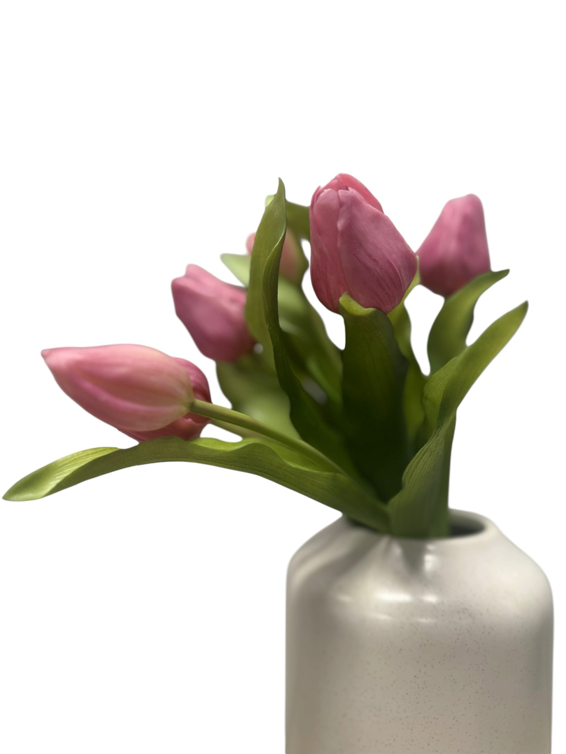 Artificial Bloom bouquet of realistic pink faux tulips with green foliage in a white ceramic vase