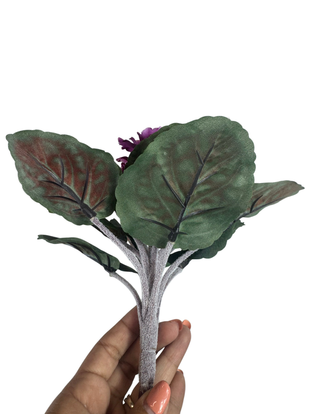 Artificial Bloom artificial African Violet with deep purple flowers and textured green leaves held in a hand