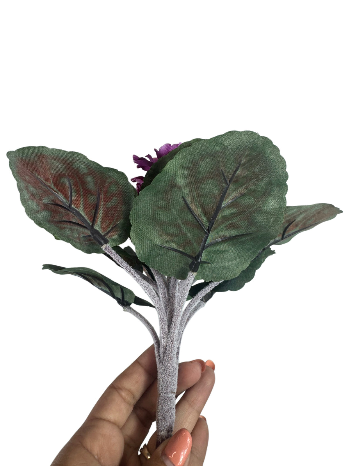 Artificial Bloom artificial African Violet with deep purple flowers and textured green leaves held in a hand