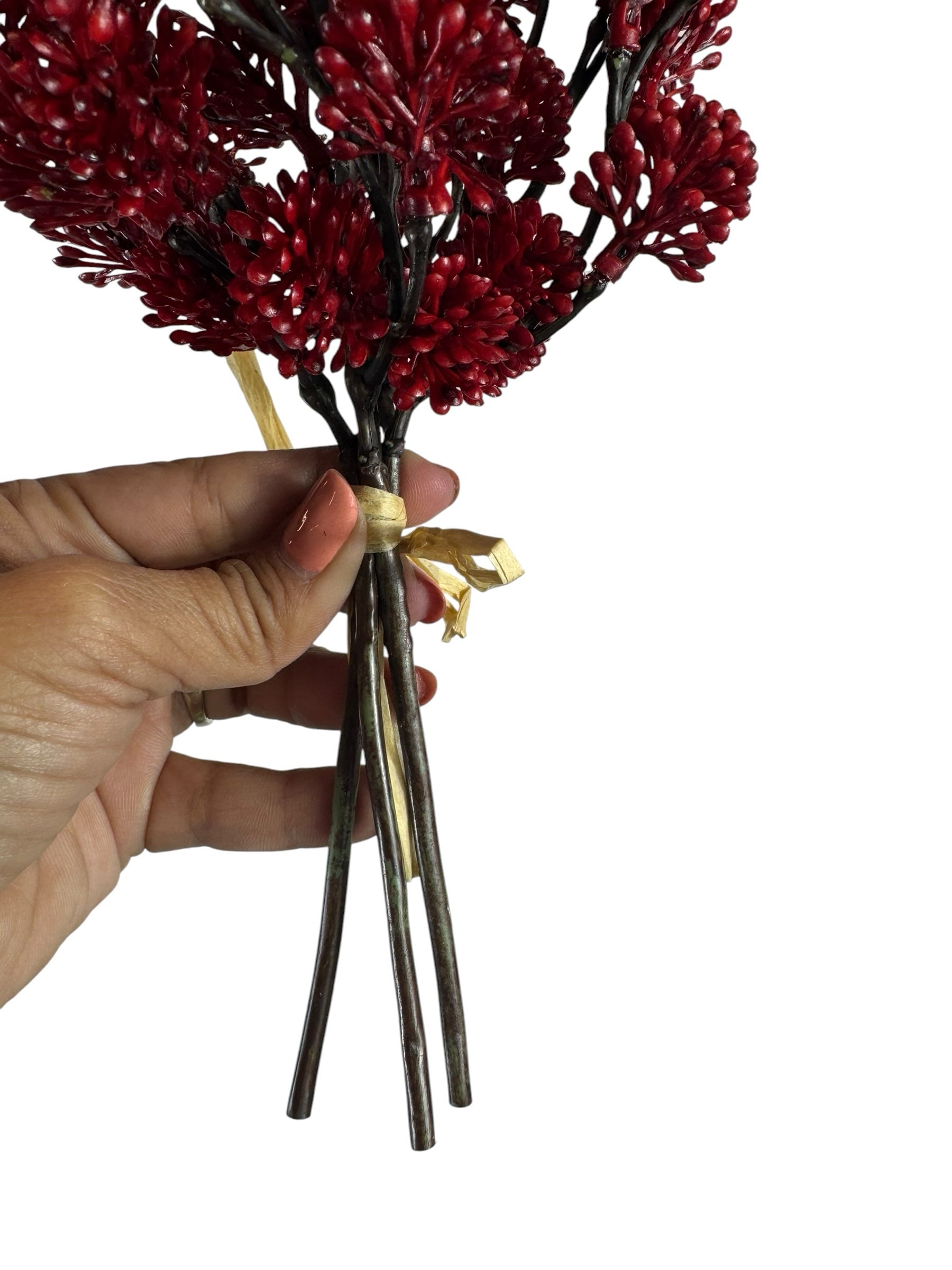 Artificial Bloom red berry branch bundle held in hand, featuring textured faux berries tied with a decorative ribbon.