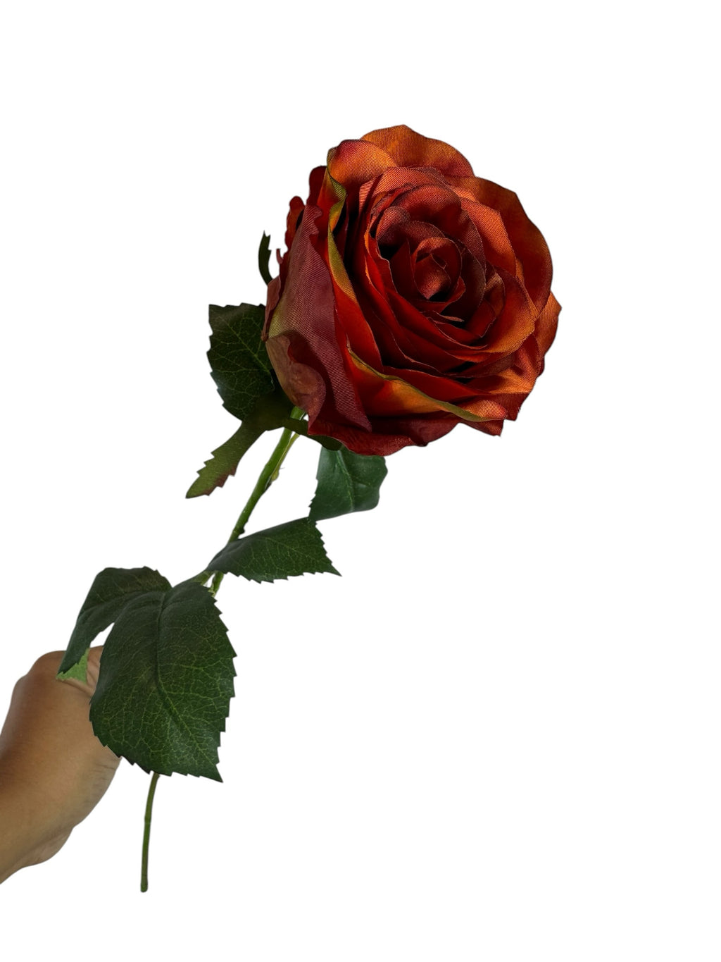 Artificial Bloom rust-orange silk rose stem with realistic green leaves held against a white background