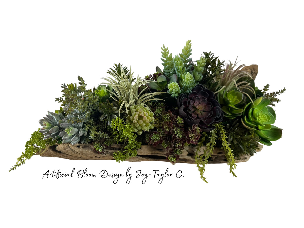 Artificial Bloom succulent arrangement featuring purple and green faux plants in a rustic weathered driftwood base.