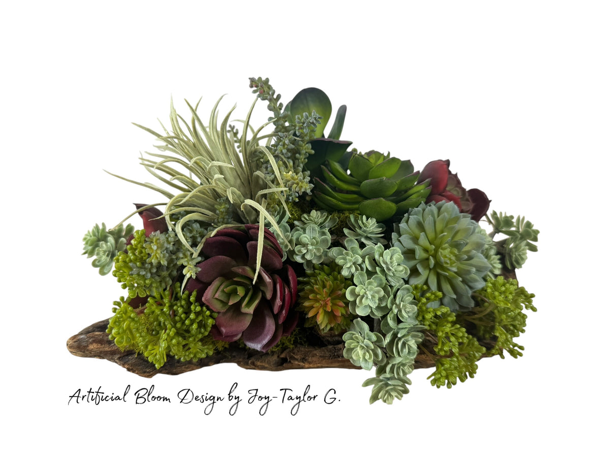 Artificial Bloom succulent arrangement featuring burgundy and green plants in a rustic natural driftwood base.