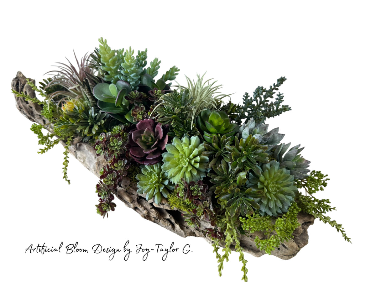 Artificial Bloom succulent arrangement featuring purple and green faux plants in a rustic weathered driftwood base.